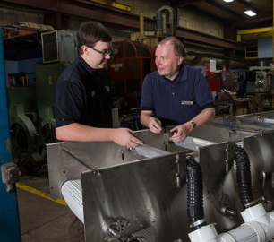 WAMIC researchers inspecting Hamill's microgreen processing machine